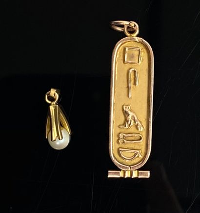 null Deux pendentifs, l'un en or jaune orné de hiéroglyphes.

L_ 3.6 cm.

4,05 grammes,...