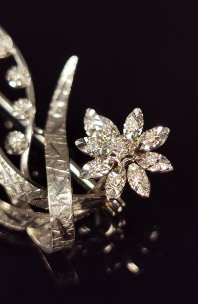 null Broche en or blanc et diamants figurant une fleur et des volutes.

L_3,9 cm.

Poids...