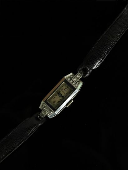 null DEA. 

Montre de dame, le cadran rectangulaire en or gris orné de dix huit petits...