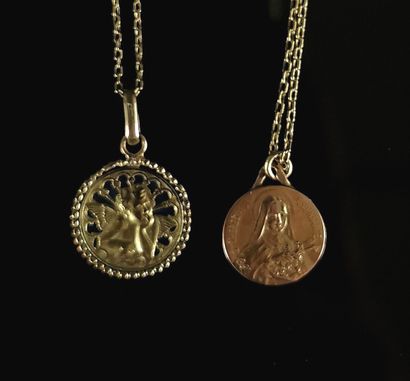null Deux chainettes en or jaune, retenant deux médailles pendentifs.

L'une à décor...
