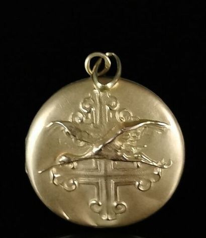 null Médaillon pendentif en or jaune, à décor repoussé d'une cigogne survolant une...