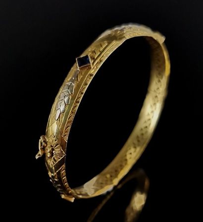 null Bracelet rigide ouvrant en or jaune ciselé orné de quatre pierres synthétiques...