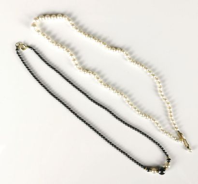 null Deux colliers en perles, l'un en perles de culture, l'autre en perles noires...
