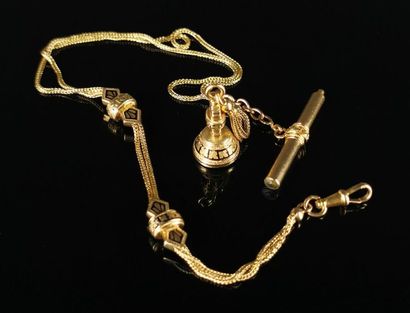 null Yellow gold watch chain with black enamel highlights, holding a winding key...