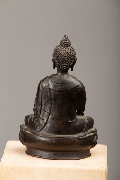 null NEPAL, XIXème siècle.

Bouddha Shakyamuni en bronze à patine brune, esquissant...