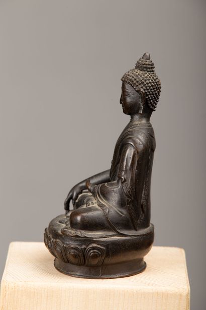 null NEPAL, XIXème siècle.

Bouddha Shakyamuni en bronze à patine brune, esquissant...