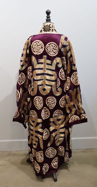 null JAPON.

Kimono en soie brodée de fils d'or, le tissu à fond violet à décor de...