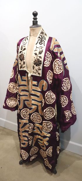null JAPON.

Kimono en soie brodée de fils d'or, le tissu à fond violet à décor de...