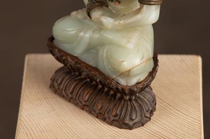 null CHINE, XIXème siècle.

Bouddha assis en jade sculpté, orné d'une parure de bronze...