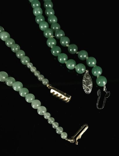 null 
Deux colliers en perles de jade verte, l'un avec le fermoir en argent et métal,...