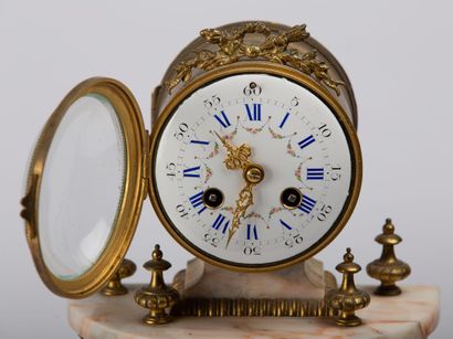 null Bronze and marble mantelpiece. 

The terminal clock with enamelled dial resting...