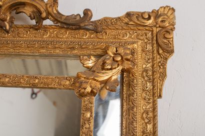 null Important mirror with parecloses in wood and gilded stucco, the pediment decorated...