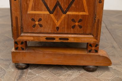 null Cupboard in marquetry of fruitwood, with geometrical decorations.

It opens...