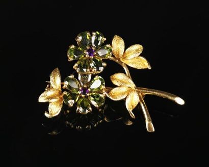 null Gold brooch featuring a flower decorated with peridots and amethysts.
Not signed.
H_4,6...