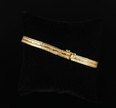 null Bracelet semi-rigide articulé en or jaune à décor de stries.
Fermoir cliquet...