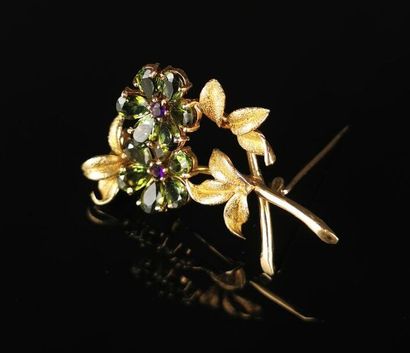 null Gold brooch featuring a flower decorated with peridots and amethysts.
Not signed.
H_4,6...