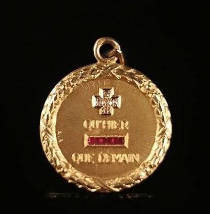 null AUGIS.
Médaille en or jaune, ornée d'un diamant et de rubis calibrés, avec l'inscription...