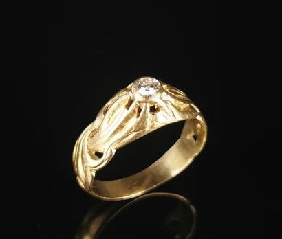 null Bague en or jaune à décor ajouré et ciselé, ornée d'un diamant en serti clos...