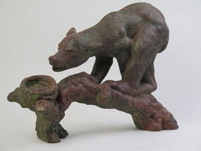 E. G Sculpture en terre cuite figurant un ours avançant sur un tronc vers un nid...