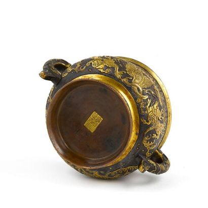 CHINE - XVIIème siècle 
Brûle-parfum de forme «gui» en bronze à patine brune et partiellement...