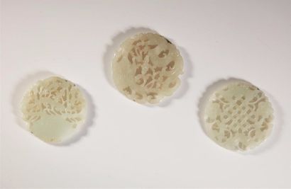 ASIE CHINE, début du XXème siècle. Trois pendentifs en jade céladon pâle Circulaires...