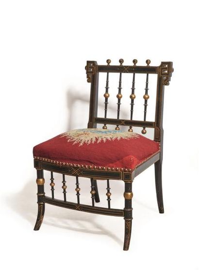 null Chaise basse à fuseaux en bois noirci et doré.

Garniture de tapisserie à décor...