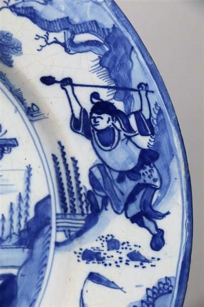 null DELFT.

Plat en faïence à décor en camaïeu bleu figurant des chinois près d'une...