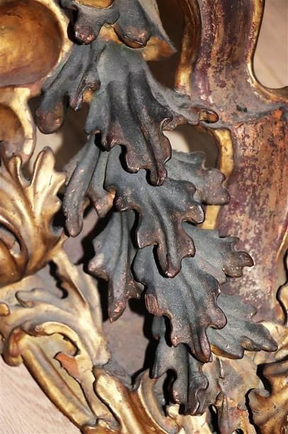 null Important élément décoratif en bois doré figurant une coquille et des rinceaux.

Travail...