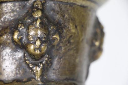 null Mortier en bronze à décor de têtes d'amours en relief.

XVIIème siècle.

H_7,8...