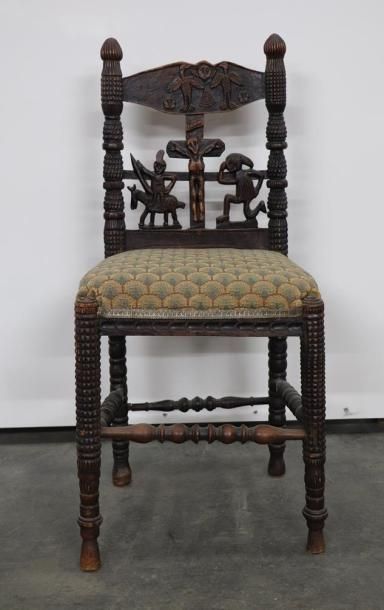 null Rare chaise en bois sculpté et ajouré, à décor naïf autour de la crucifixion.

Le...