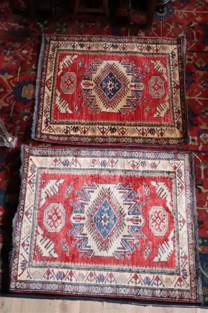 null Paire de tapis kazak en laine à fond rouge.

L_97 cm l_84 cm et L_98 cm l_82...