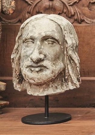 null Tête d'homme aux longs cheveux qui encadre son visage, sculpté en pierre calcaire....