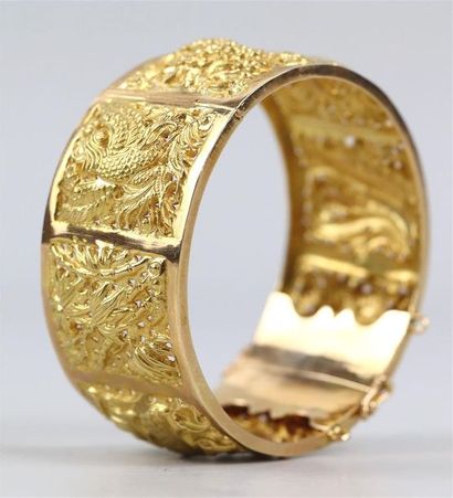 null Bracelet en or jaune repoussé à décor de dragons, phénix et fleurs.

D_6 cm,...