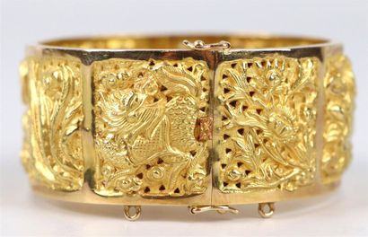 null Bracelet en or jaune repoussé à décor de dragons, phénix et fleurs.

D_6 cm,...