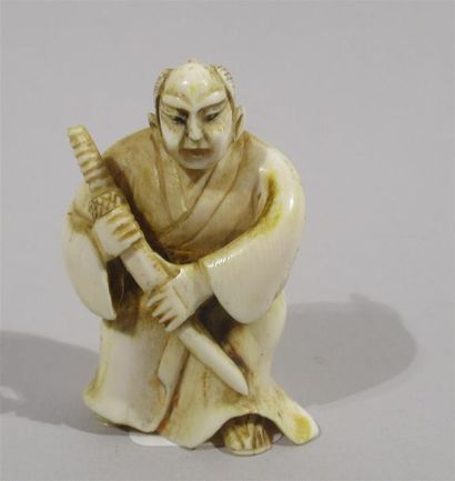 null Netsuke en ivoire bien sculpté d'un Samouraï en habit de cérémonie tenant un...