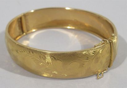 null Bracelet rigide en or jaune 18 K (750/oo) à décor ciselé de rinceaux feuillagés...