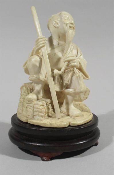 null Statuette en ivoire finement sculptée d'un souriant chinois assis rue un rocher,...