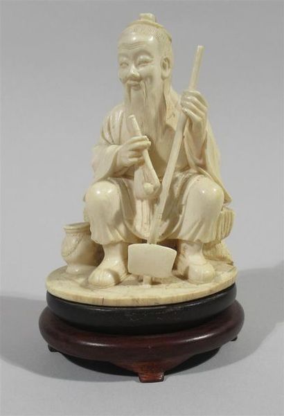 null Statuette en ivoire bien sculptée d'un souriant paysan assis, tenant un sarcloir...