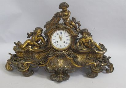 null Large bronze clock surmounted by three angels, the round white enamelled dial...