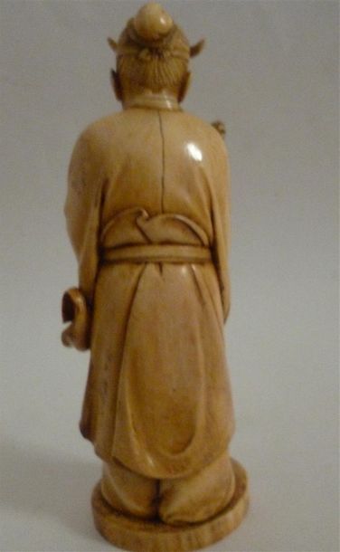 null Okimono en ivoire finement sculpté et bien patiné d'un sage tenant un ushiwa...