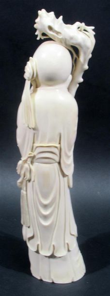 null Okimono en ivoire sculpté à décor d'un sage chauve portant une branche de fleurs...