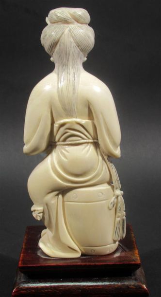 null Okimono en ivoire sculpté figurant une femme agenouillée tenant deux coupes...