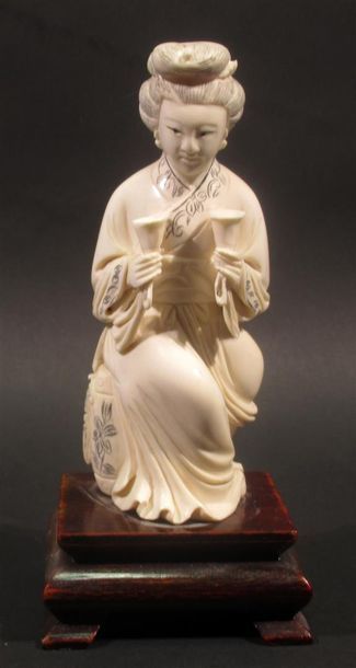 null Okimono en ivoire sculpté figurant une femme agenouillée tenant deux coupes...