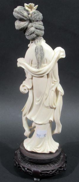 null Okimono en ivoire sculpté à décor d'une femme tenant une pivoine arbustive dans...