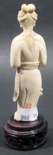 null Sujet en ivoire sculpté figurant une femme tenant une fleur - Signé à l'arrière...