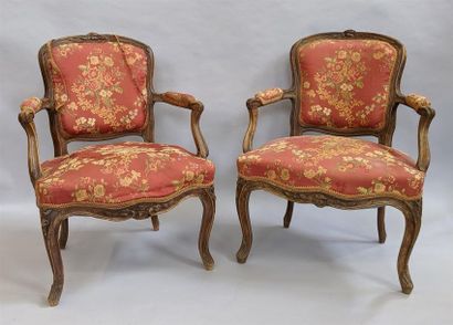 null Suite de deux fauteuils en noyer mouluré et sculpté à décor de fleurettes, les...