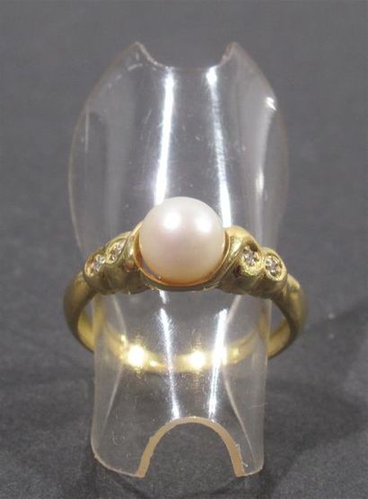 null Bague en or jaune 18 K (750/oo) surmontée d'une perle fantaisie épaulée de quatre...