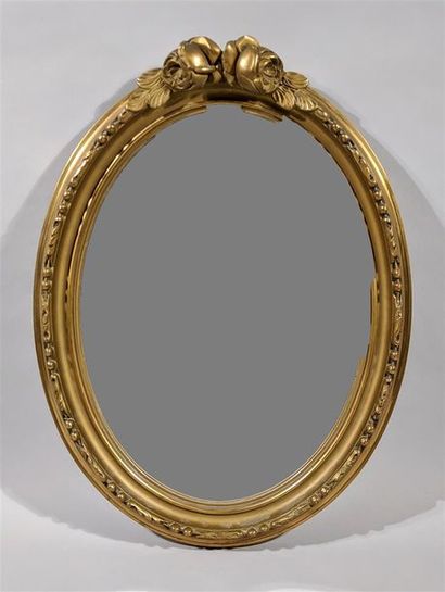 null MIROIR moderne ovale en bois et stuc dorés à décor de roses. 48 x 38 cm. 