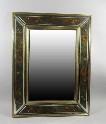 null MIROIR biseauté à verre églomisé à décor de rinceaux de feuilles polychromes,...