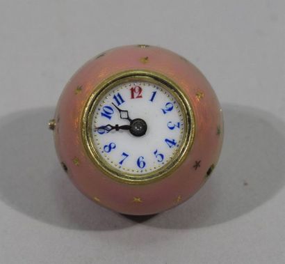 null MONTRE DITE "BOULE DE GENEVE" en métal doré à décor émaillé rose sur fond étoilé,...